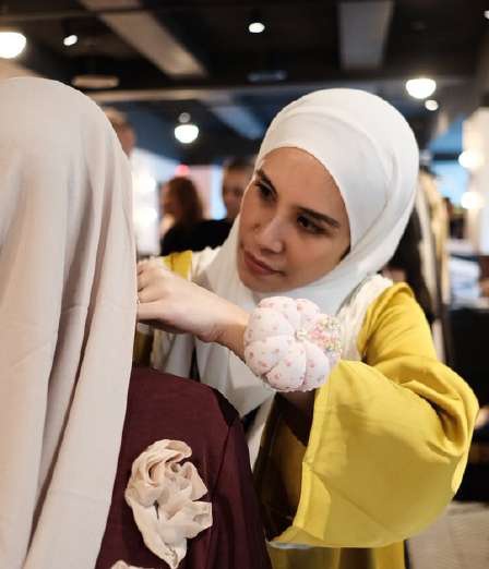 Zafira tending to a model’s final backstage details