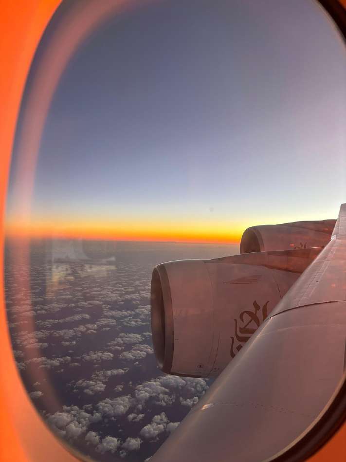 Sunset over clouds seen through an airplane window